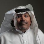 Portrait of a middle-aged Arabic man in traditional attire with a neutral background.